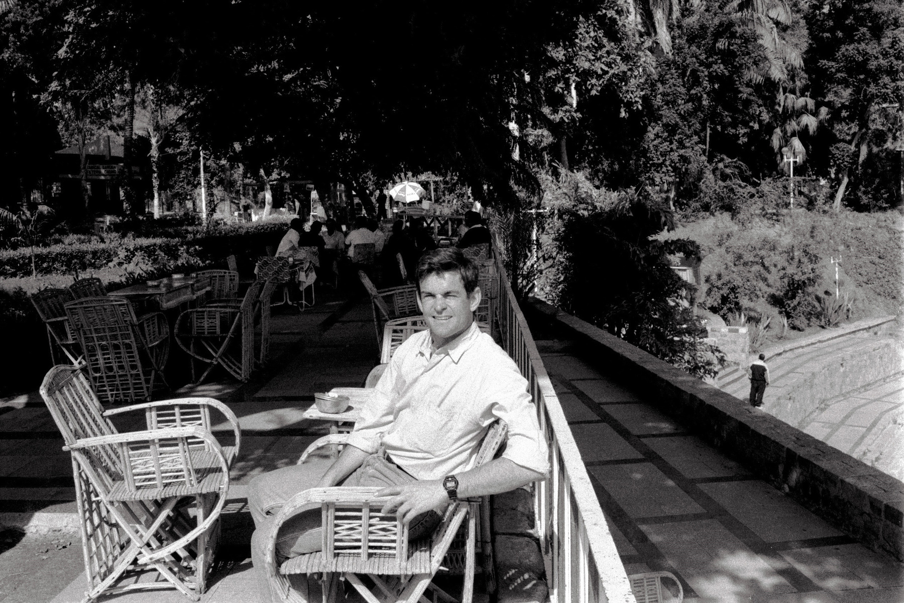 Man seated in a sunny botanical garden in Egypt