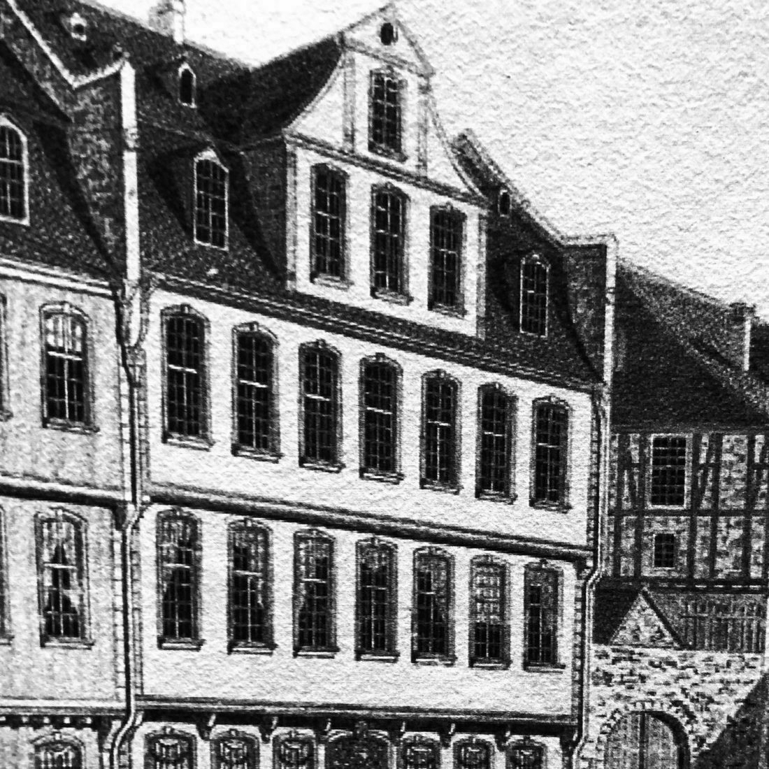 Auto-generated description: A black and white drawing depicts an old European-style building with multiple windows and steeply pitched roofs.